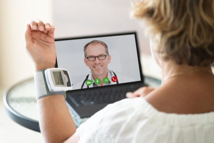 A patient talking to her doctor using a laptop