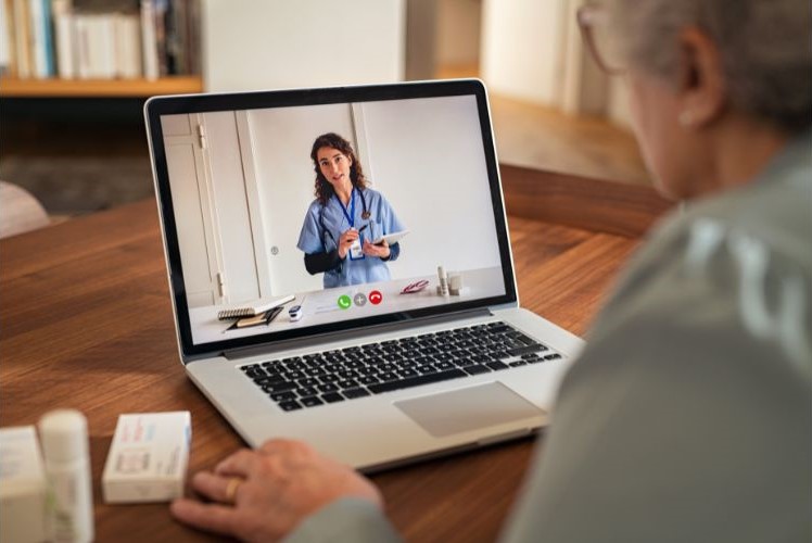 A senior woman talking to her doctor with her laptop